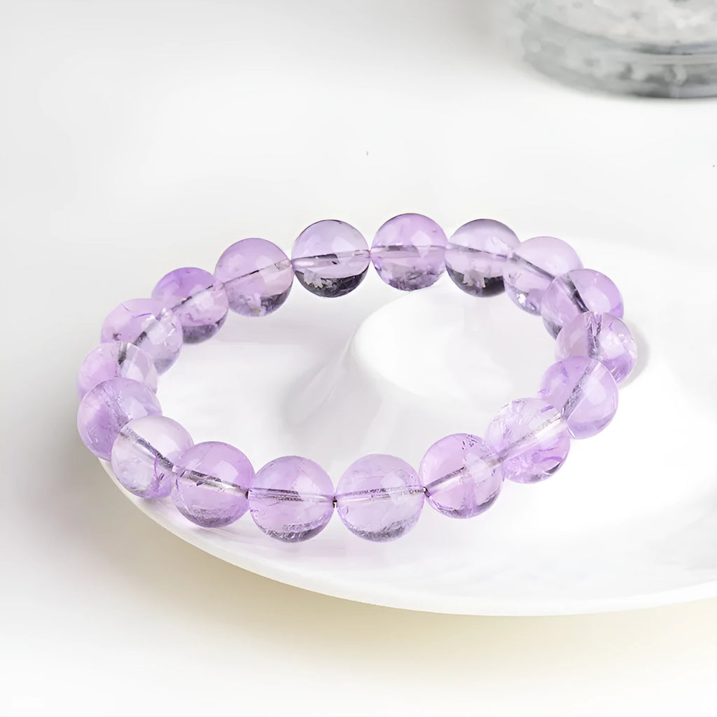 Lavender amethyst round bead bracelet with water ripple pattern on a table.