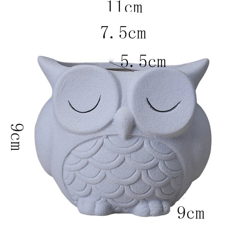 Handmade frosted ceramic owl succulent pot in pastel colour on a wooden surface.