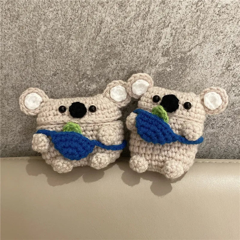 Hand-knitted grey koala bear backpack case for Apple AirPods on a wooden table.