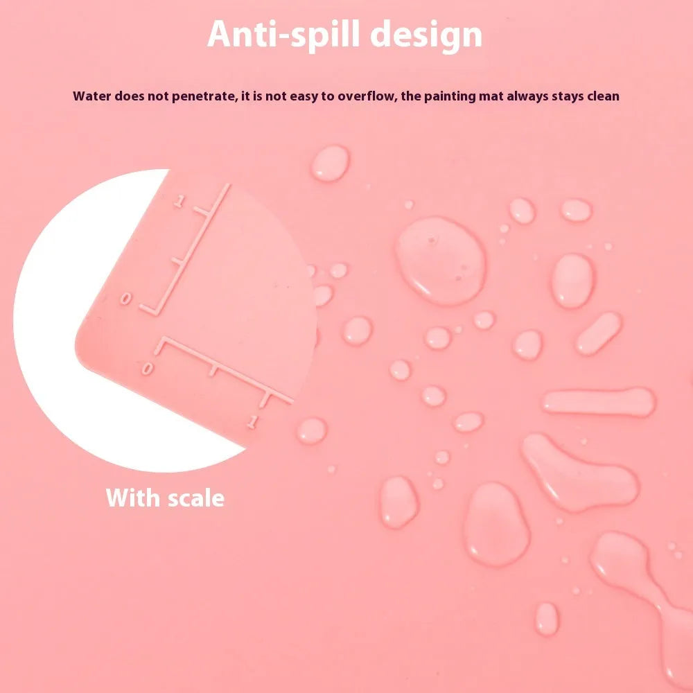 Light blue silicone painting mat with two round bowls, measuring 50cm by 40cm, on a wooden table.