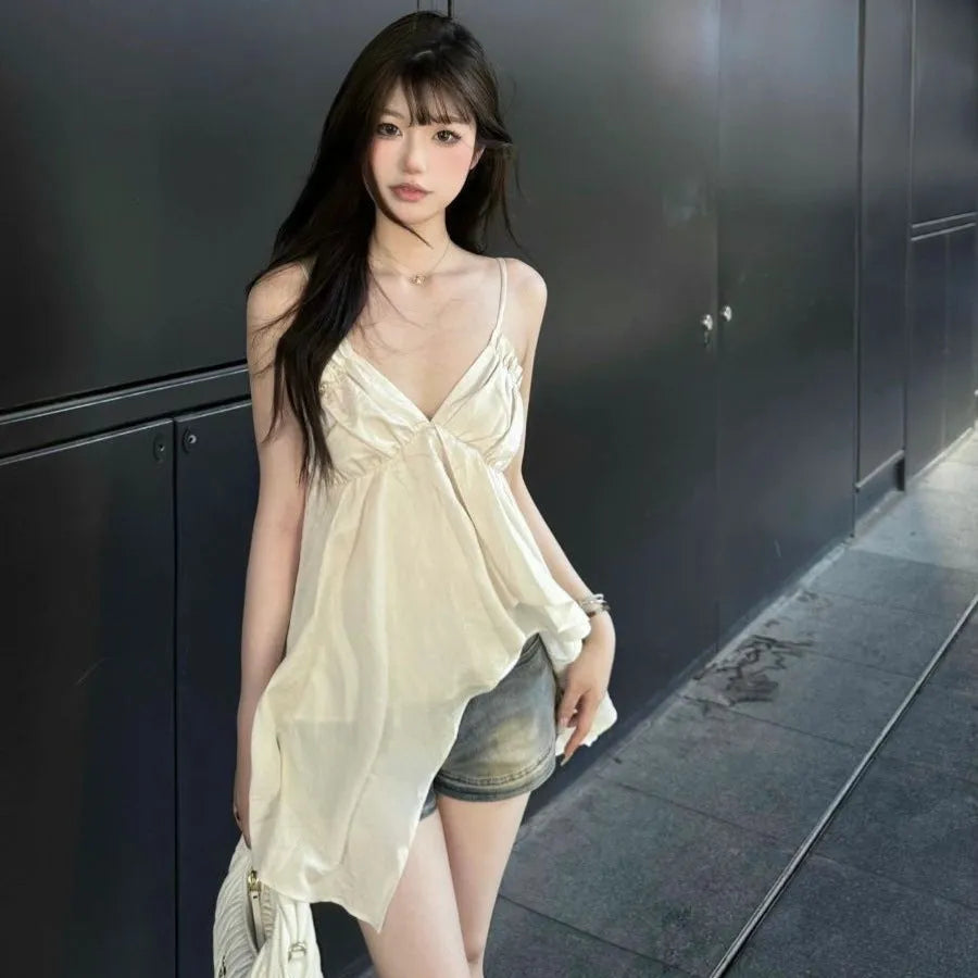 Apricot polyester sleeveless vest top with spaghetti straps, double-connector strap style, and asymmetric splicing detail.