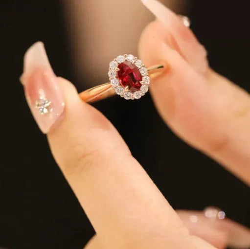 Silver plated ring with gold pigeon design and red blood gemstone inlay on a floral pattern band.