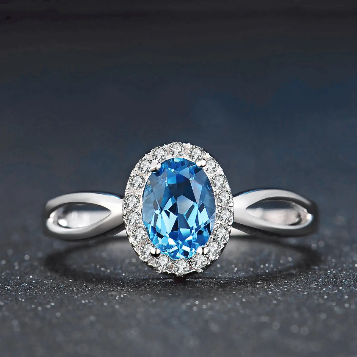 A four-piece women's sterling silver jewellery set with blue topaz gems, showing geometric earrings, ring, pendant, and necklace.