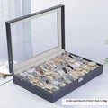 Grey leather watch storage box with clear dustproof lid showing multiple watch slots inside.