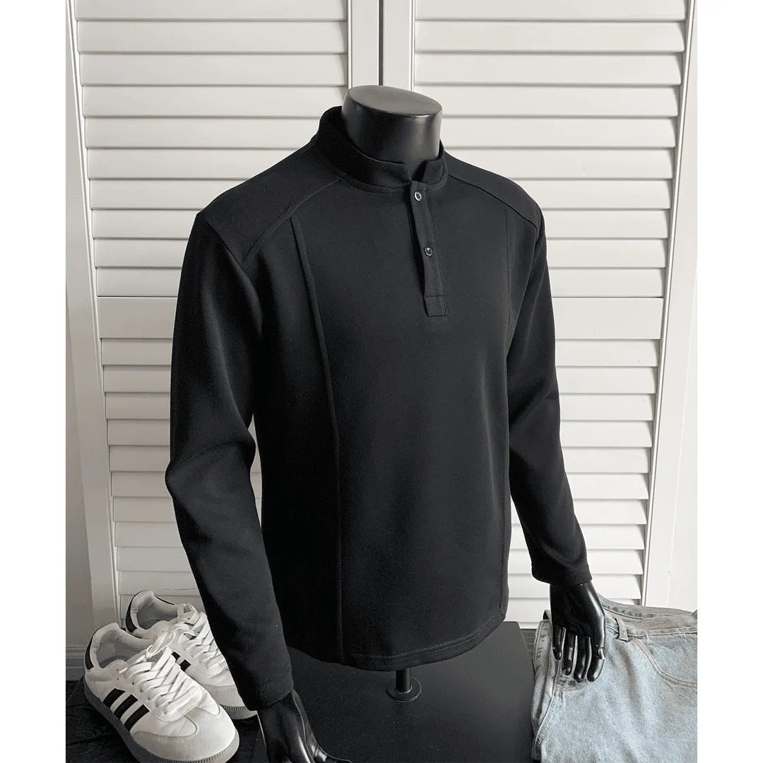Men's black asymmetric patchwork long sleeve polo shirt with a stand-up collar, laid flat.
