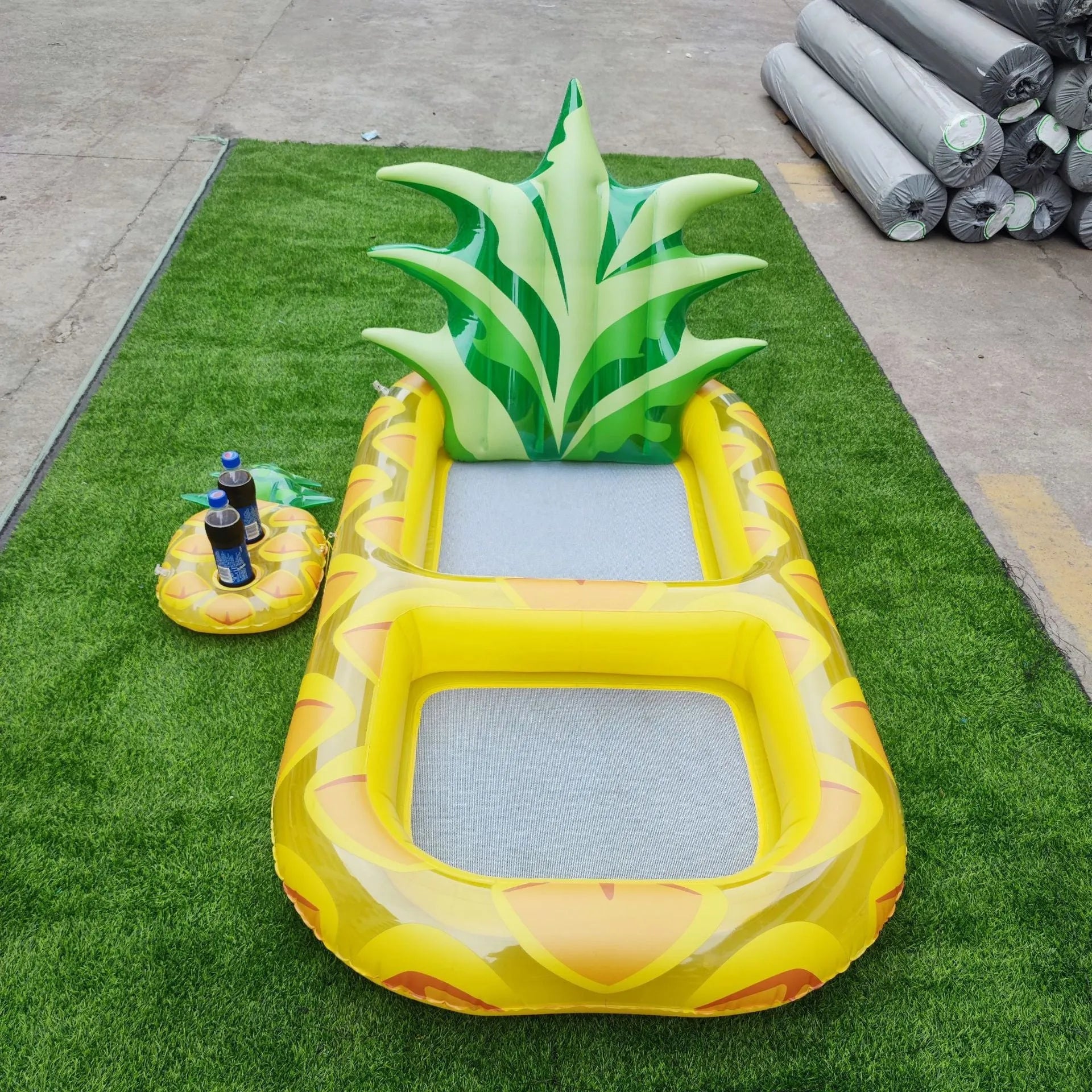 Inflatable pineapple pool lounger with cup holder floating on water in yellow colour