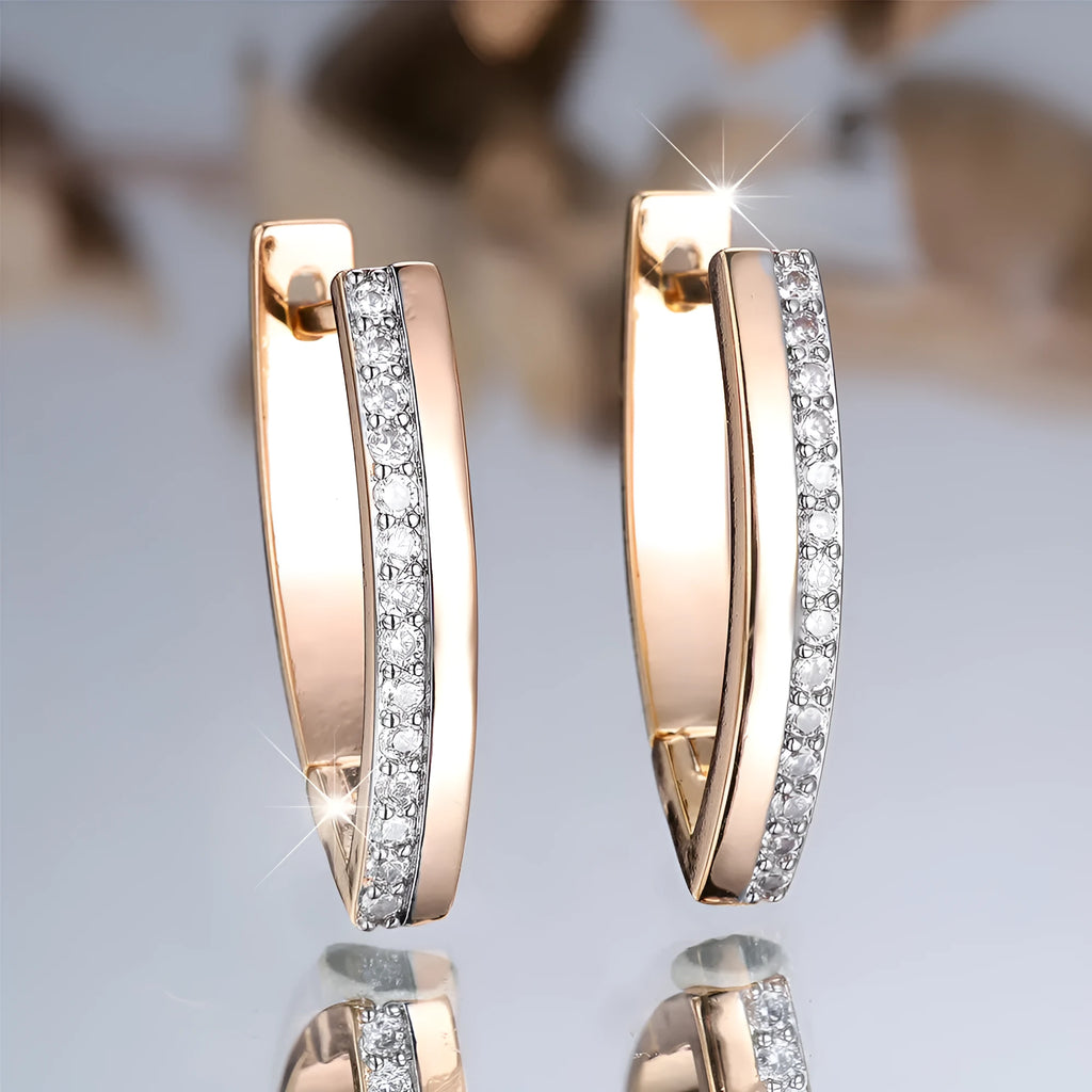 Women's geometric V-shape ear clips in champagne gold with white diamond detail on copper construction