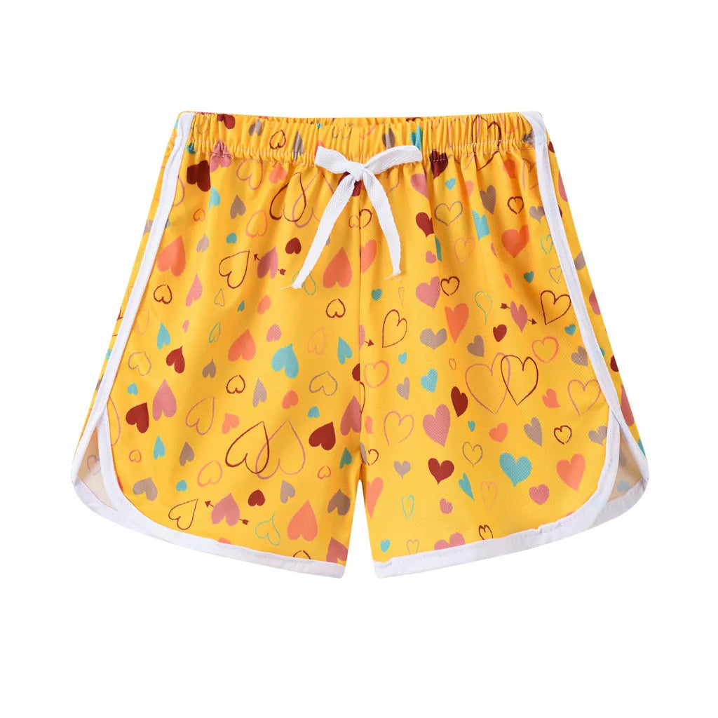 Children's colourful polyester shorts with elastic waistband, showing patterns like stripes, pineapples, and kittens.