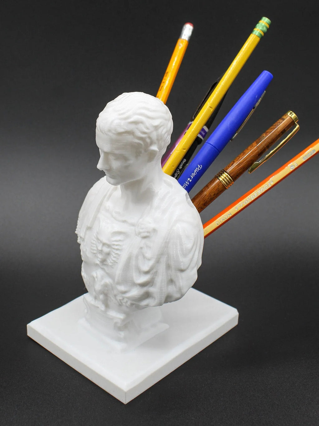 White synthetic resin pen holder with American cartoon character modelling on a desk.