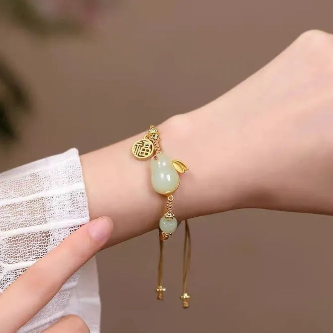 Hetian jade geometric rabbit charm bracelet on a yellow string for women.
