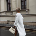 White longline knitted cardigan jacket with long sleeves on a hanger