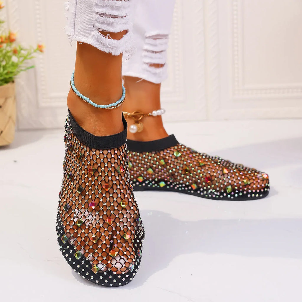Colourful rhinestone detail on women's white mesh flat sandals with a round toe and rubber sole.