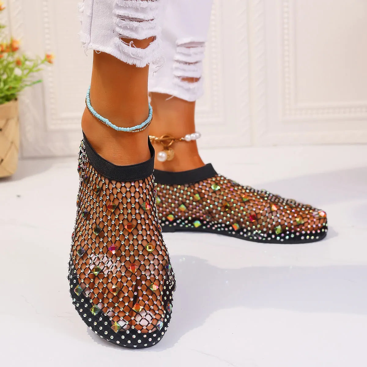 Colourful rhinestone detail on women's white mesh flat sandals with a round toe and rubber sole.