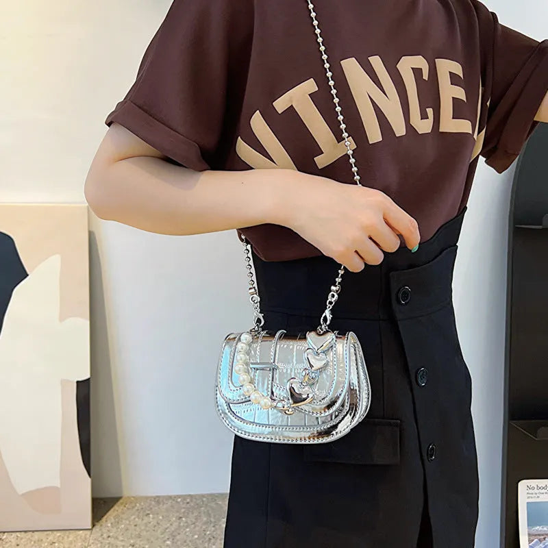 Laser pearl tote saddle girl mini crossbody bag in a horizontal square shape, shown in silver colour.