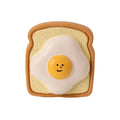 Yellow and green cartoon bread egg shaped latex squeaky toy for dogs on a white background.