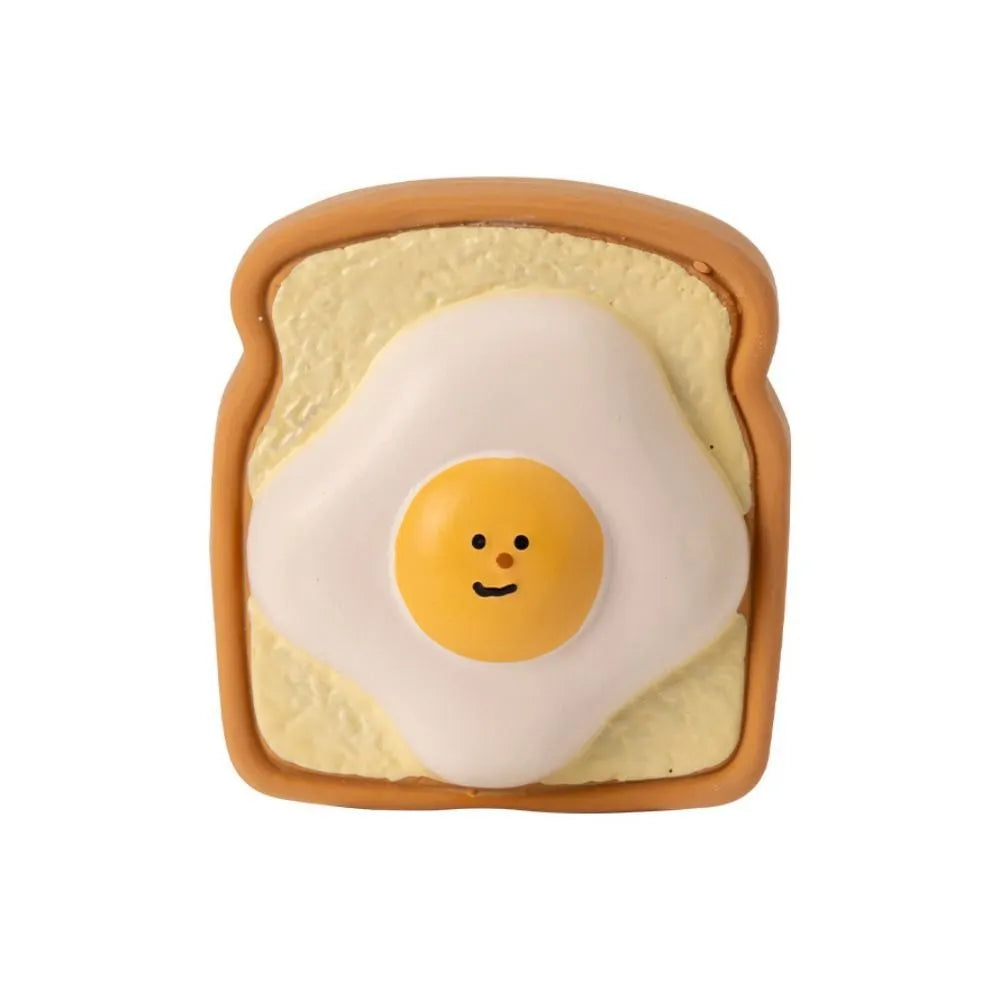 Yellow and green cartoon bread egg shaped latex squeaky toy for dogs on a white background.