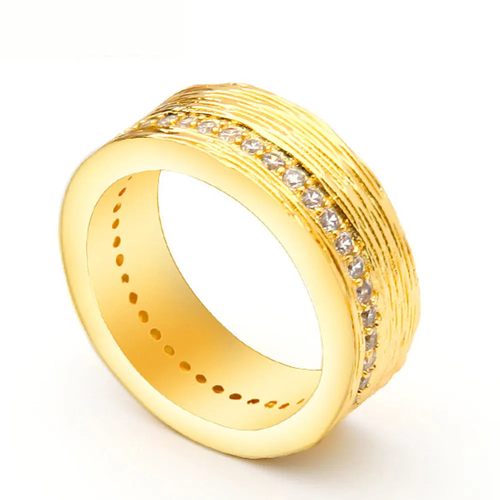 Geometric gold-coloured zircon ring for women on a plain background.