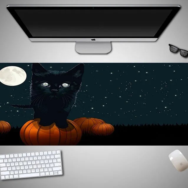 Oversized Halloween-themed gaming mouse pad on a desk, showing anti-slip base and graphic design.