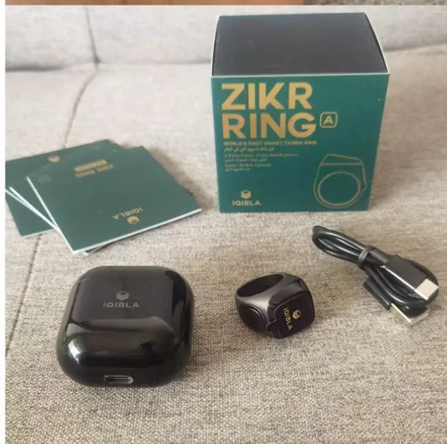 Silver smart ring with a button and small OLED display on a finger.
