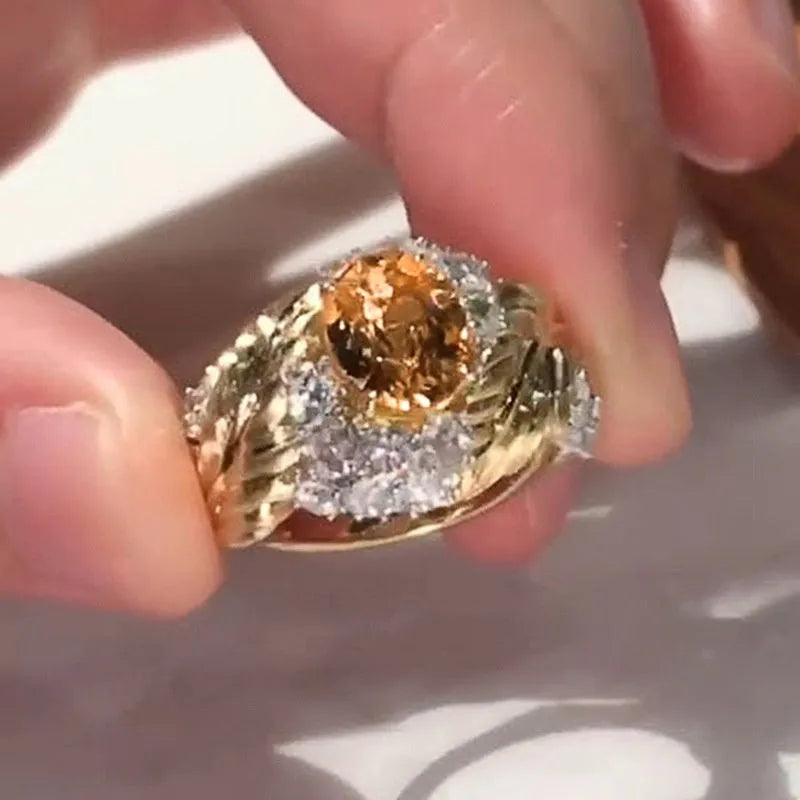 Gold-toned copper women's ring with an embossed feather design and a central yellow zircon stone.