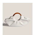 Niche horn bag in black or white PU leather with acrylic ring handle and fold detail for daily matching.