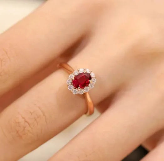 Silver plated ring with gold pigeon design and red blood gemstone inlay on a floral pattern band.
