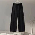 Women's black polyester pleated top and wide leg trousers suit set on a hanger