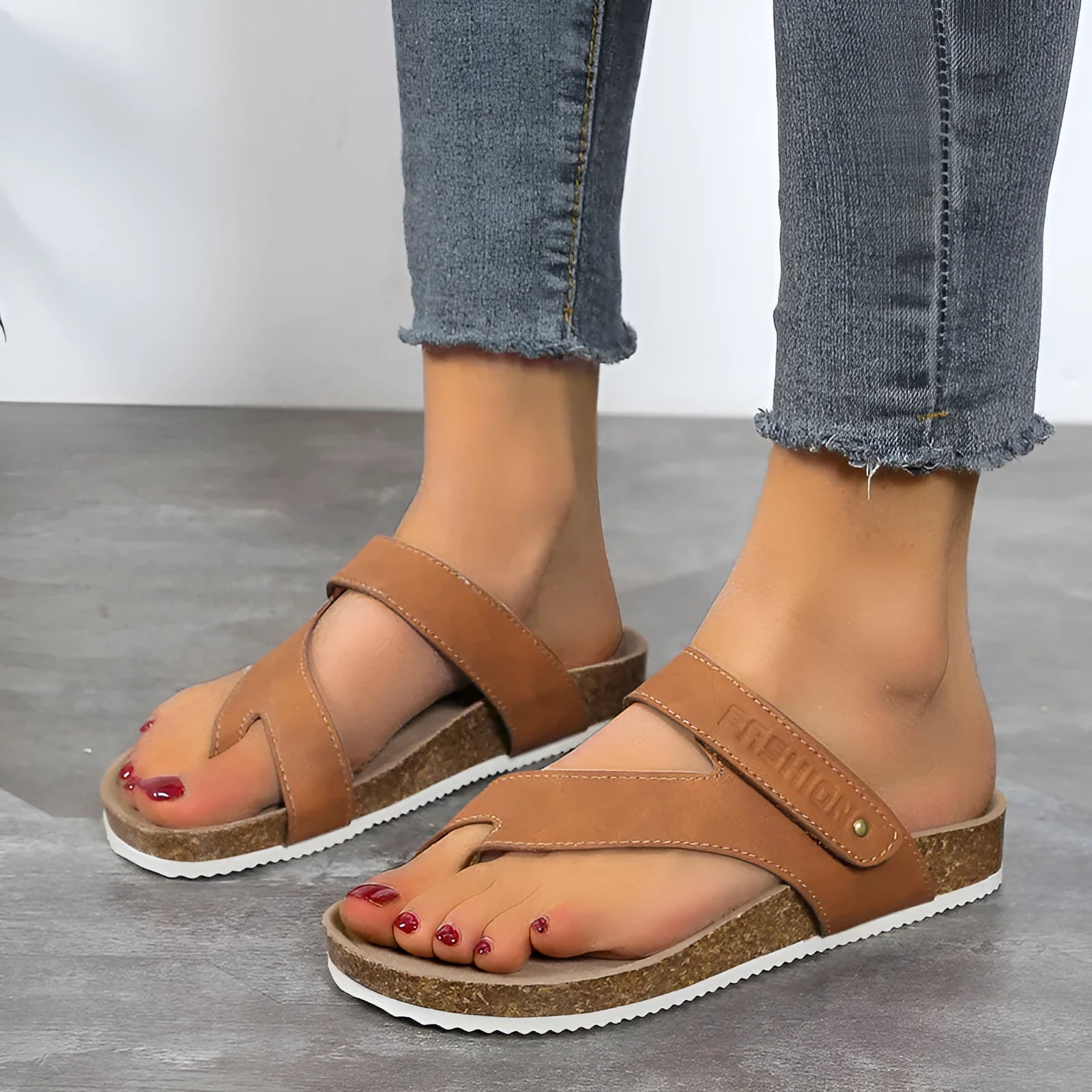 A pair of thick-soled flat toe ring flip flops in a solid colour, showing the foam sole and artificial PU upper.