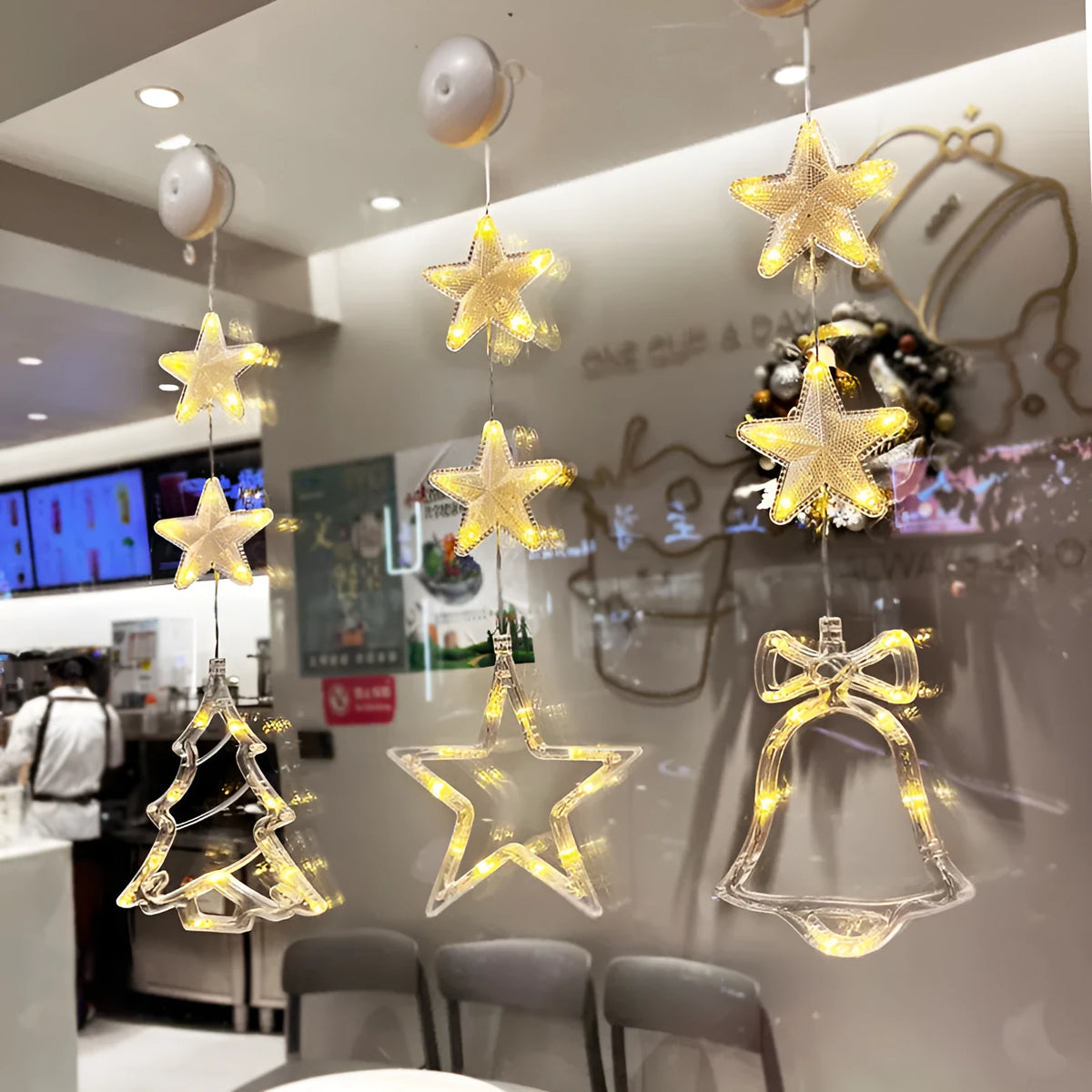 Set of three Christmas LED star window lights with suction cups on a glass window, warm glow, plastic housing, battery operated