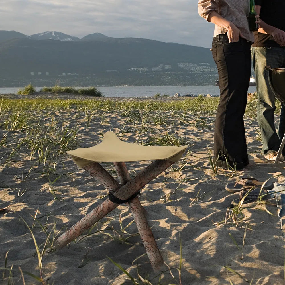 Folding portable camping stool with triangular fabric seat in black for outdoor use