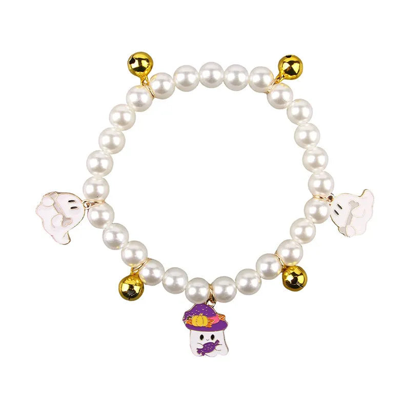 Three pearl and bell necklaces for pets laid out, suitable for cats and small dogs.