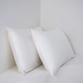 Pair of bamboo fibre satin pillowcases in white colour with twill weave texture on bed