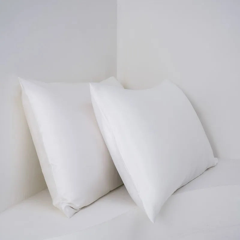 Pair of bamboo fibre satin pillowcases in white colour with twill weave texture on bed