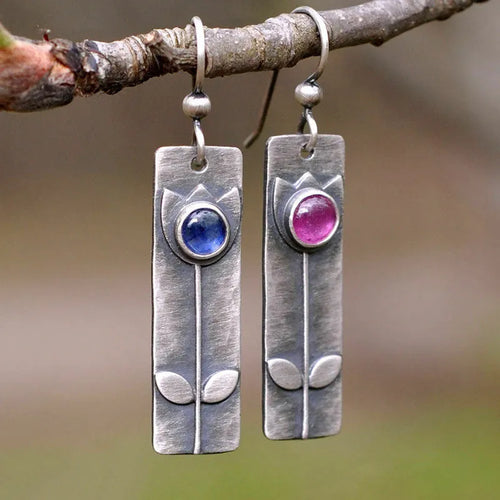 Antique finish red sapphire earrings with a geometric ellipse shape on electroplated metal.