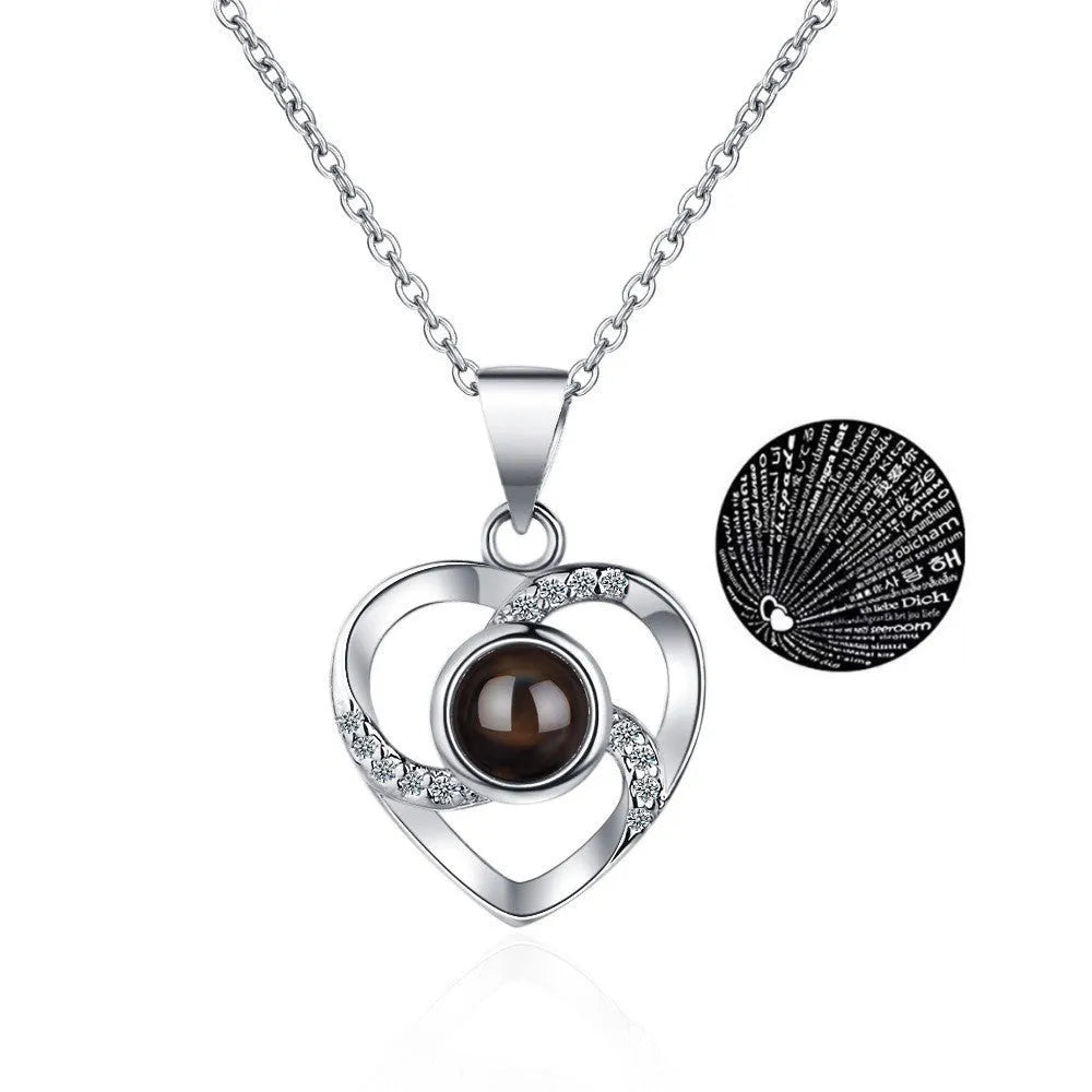 Rose gold heart-shaped projection necklace in copper with O chain, displaying 100 languages love message.