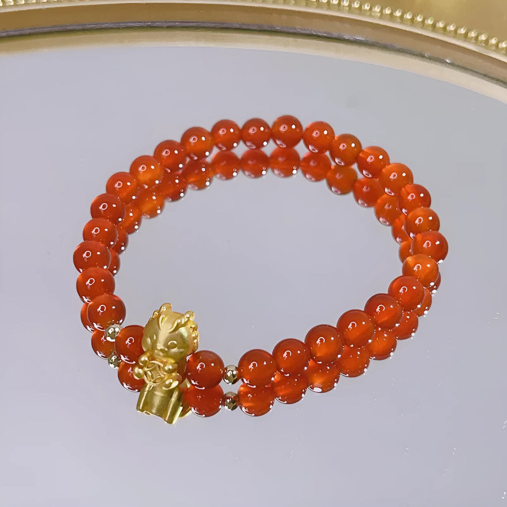 Close-up of a red agate bracelet with a Chinese dragon design on a woman's wrist.