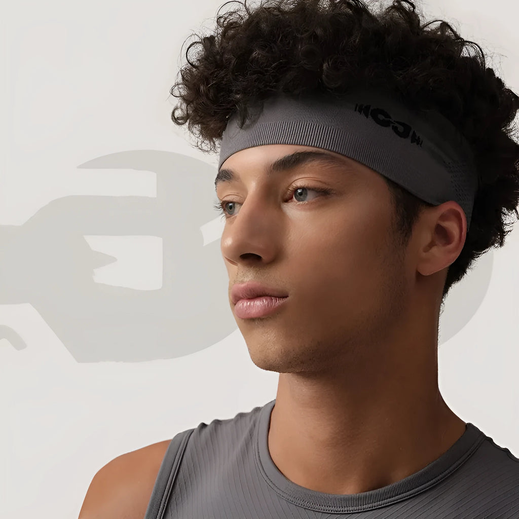 Seamless knitted unisex exercise hair band in black, shown worn during activity.