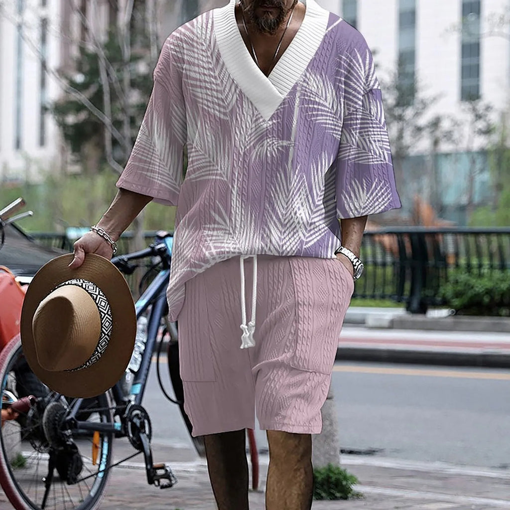 Man wearing a printed drop-shoulder knitted short-sleeved top with matching shorts in a solid colour.