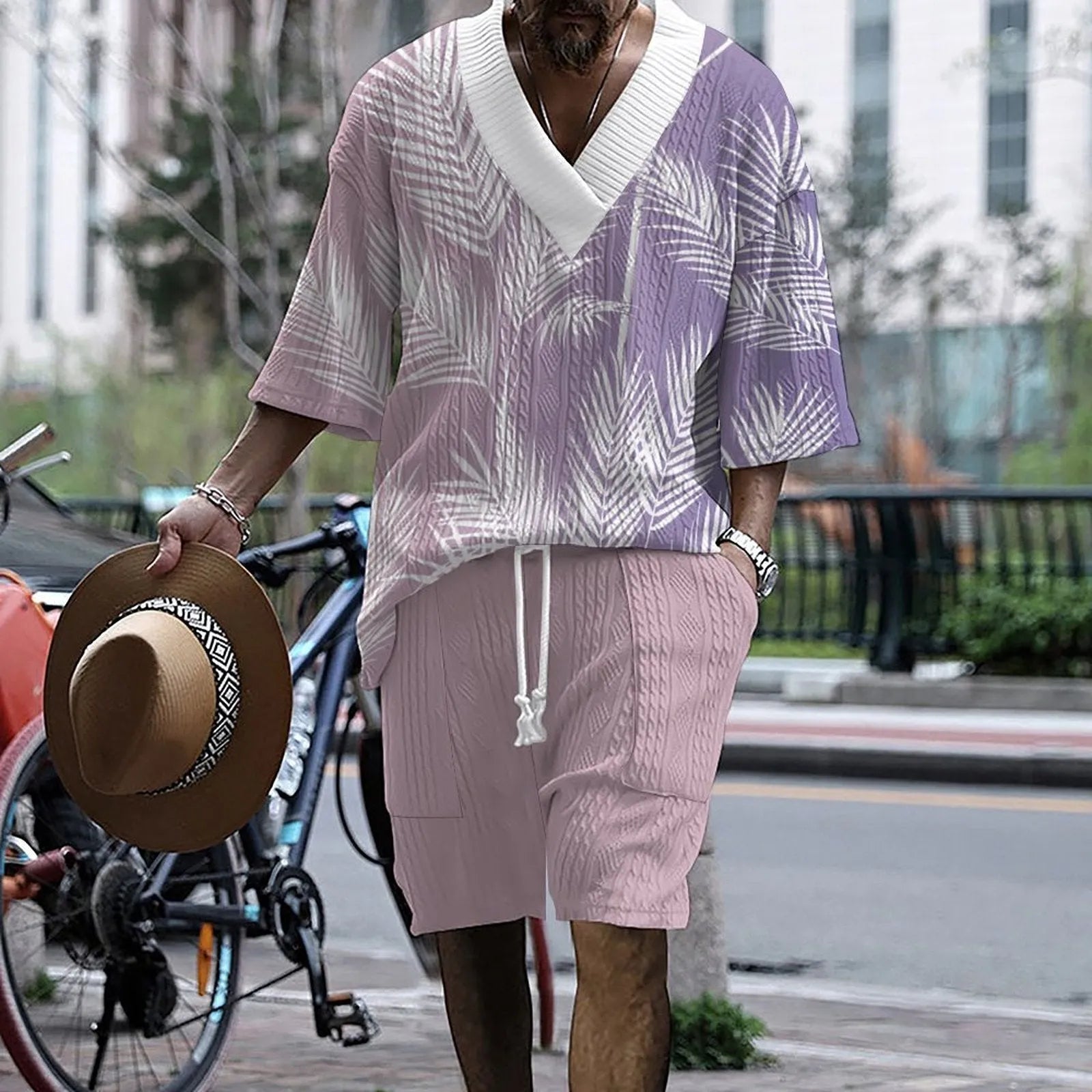 Man wearing a printed drop-shoulder knitted short-sleeved top with matching shorts in a solid colour.