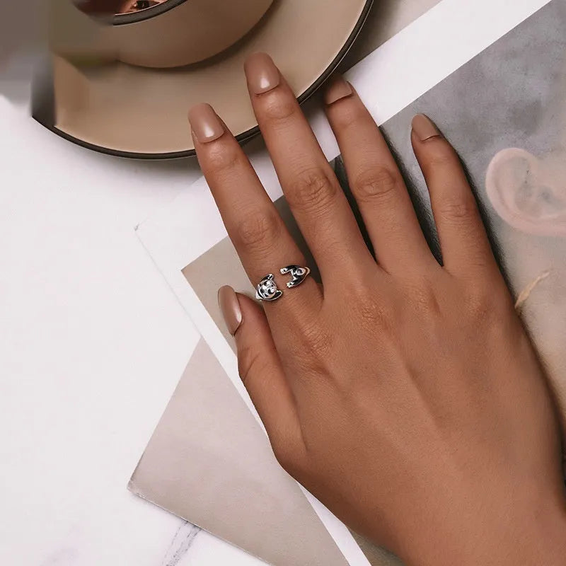 Adjustable sterling silver panda ring with white gold plating on a finger