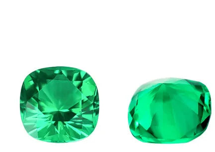 Collection of polished green cultivated emerald gemstones in various shapes and sizes on a white background.