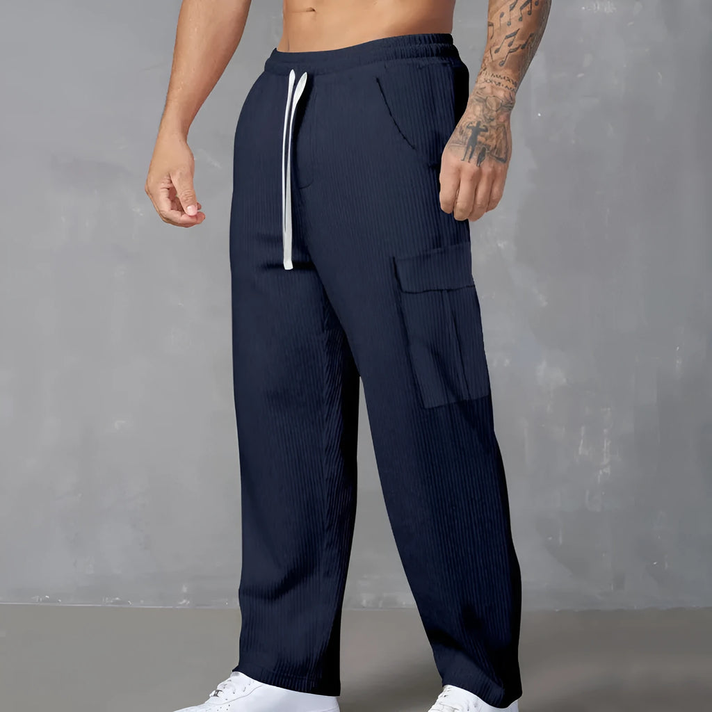 Men's navy blue corduroy cargo trousers with a drawstring waist and straight legs laid flat.