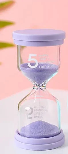 Handmade glass sand timer with blue sand, showing modern simplicity style on a desk.