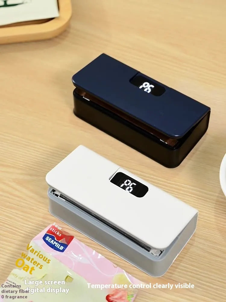 Small white handheld heat sealing machine for plastic food bags on a kitchen worktop.