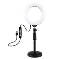 Black ring-shaped desktop fill light with two mobile phone holders placed on a table