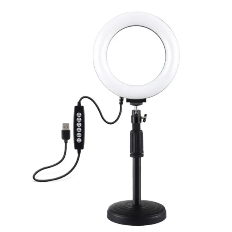 Black ring-shaped desktop fill light with two mobile phone holders placed on a table