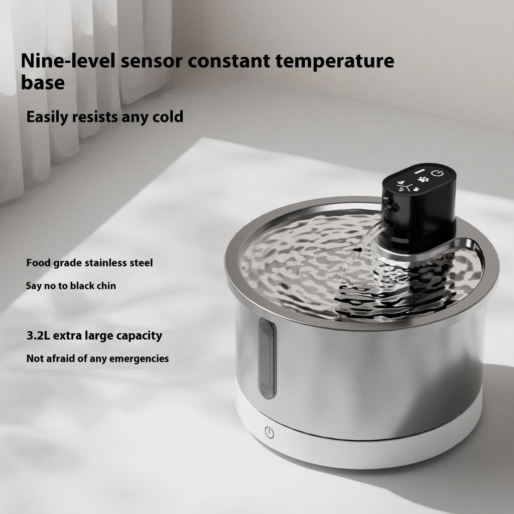 Stainless steel cat and dog water fountain with white heating base on a kitchen floor.