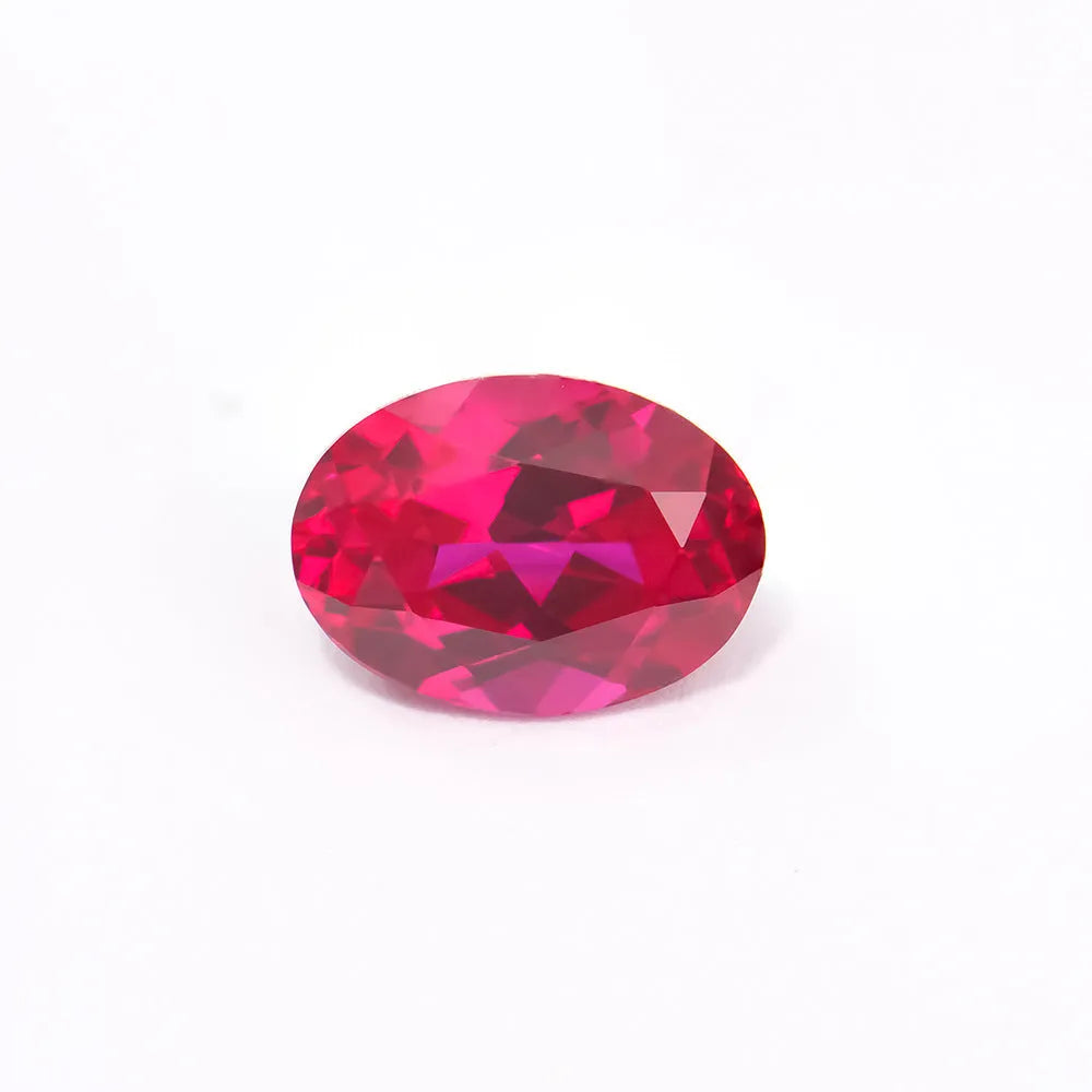 Cultivated ruby gemstone in various cuts including round, princess, oval and pear shapes on white background.