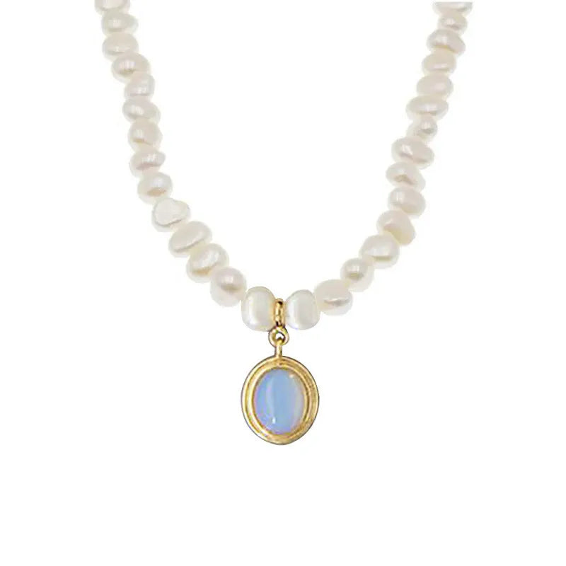 Round geometric sterling silver necklace with an irregular white pearl pendant on a chain.