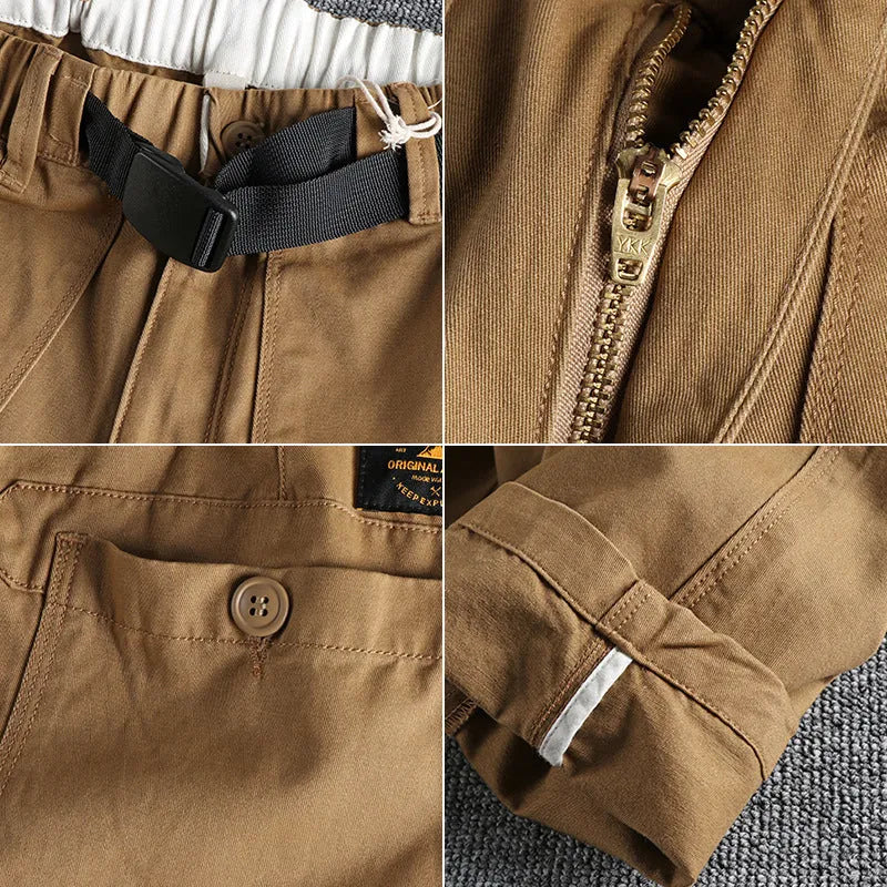 A pair of men's khaki cotton work trousers with a mid waist and zip fly on a plain background.